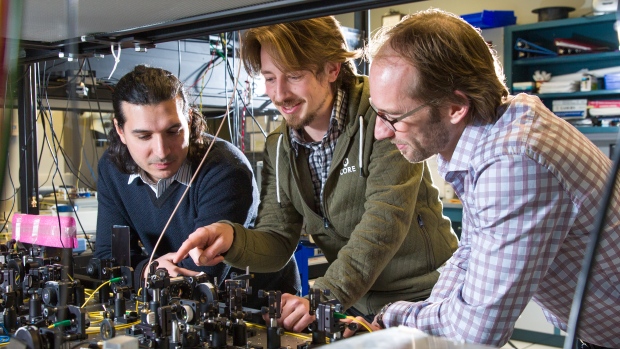 From left, postdoctoral fellows Daniel Oblak, Erhan Saglamyurek and physics professor Wolfgang Tittel, look over lab equipment. Their team recently published a paper on quantum computing advances.