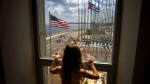 In this Aug. 14, 2015 file photo, a girl looks out from the newly opened U.S. Embassy after the U.S. flag raising ceremony in Havana, Cuba, as part of officially restored diplomatic relations. (AP Photo/Ramon Espinosa, File)